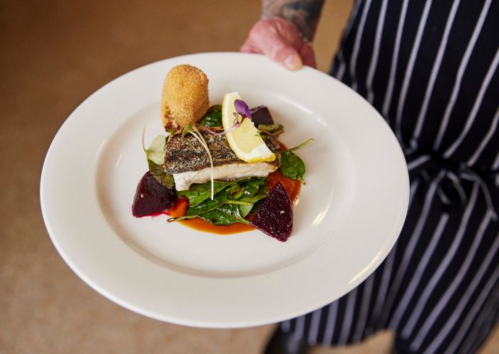 Waiter with a plate of food at Morrisons, Moama