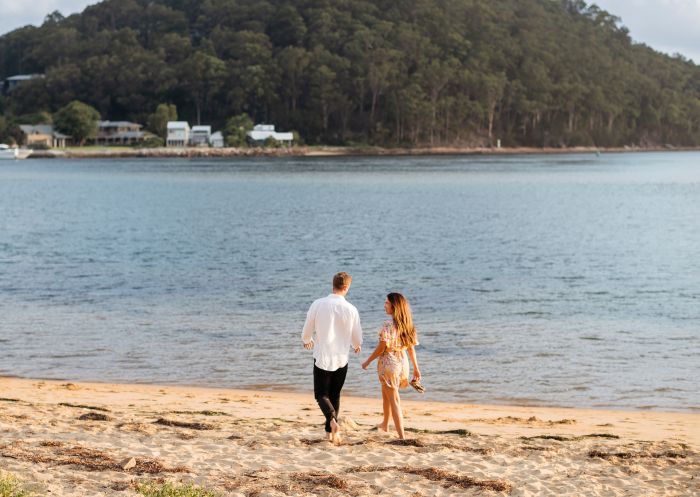 Couple enjoying a walk along Ettalong Beach at sunset, Central Coast